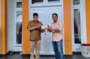 Penyerahan miniatur ekskavator oleh PT Kuala Tuha Sejati kepada Teuku Raja Keumangan sebagai simbol dukungan investasi di Nagan Raya.