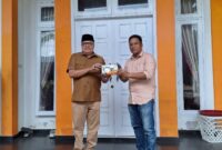 Penyerahan miniatur ekskavator oleh PT Kuala Tuha Sejati kepada Teuku Raja Keumangan sebagai simbol dukungan investasi di Nagan Raya.