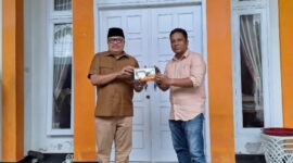 Penyerahan miniatur ekskavator oleh PT Kuala Tuha Sejati kepada Teuku Raja Keumangan sebagai simbol dukungan investasi di Nagan Raya.