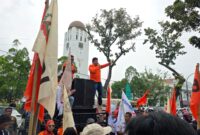 Ratusan massa Partai Buruh bersama berbagai elemen menggelar aksi damai memperingati Hari Buruh Internasional (May Day) di depan Kantor Gubernur Sumatera Utara, Medan, Jumat (1/5/2026). Dalam aksi tersebut, massa menyampaikan sejumlah tuntutan terkait perlindungan buruh sekaligus memberikan bunga kepada polisi sebagai bentuk apresiasi atas pengamanan yang humanis.