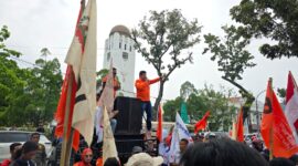 Ratusan massa Partai Buruh bersama berbagai elemen menggelar aksi damai memperingati Hari Buruh Internasional (May Day) di depan Kantor Gubernur Sumatera Utara, Medan, Jumat (1/5/2026). Dalam aksi tersebut, massa menyampaikan sejumlah tuntutan terkait perlindungan buruh sekaligus memberikan bunga kepada polisi sebagai bentuk apresiasi atas pengamanan yang humanis.