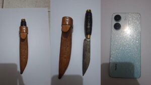Barang bukti kasus curas di Lampung Timur berupa senjata tajam jenis badik beserta sarungnya dan satu unit telepon genggam yang diamankan polisi.